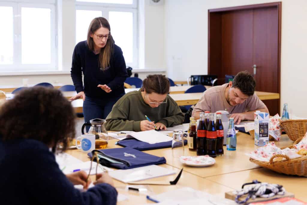 Dominique hilft Schülern im Theorieunterricht
