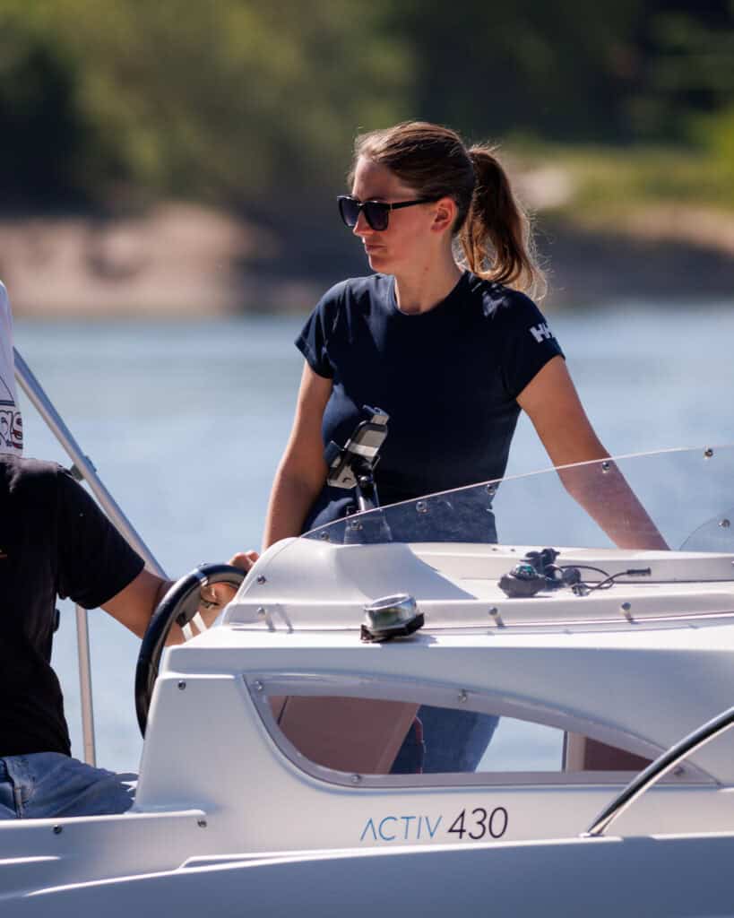 Dominique Spindler die Inhaberin der Bootsschule lacht auf dem Boot auf dem Wasser