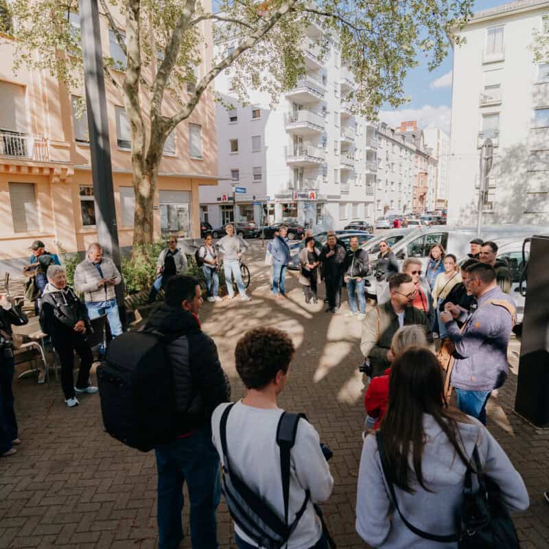Gruppe des FotoWalks trifft sich und Veranstalter David Teloke teilt die Farben aus