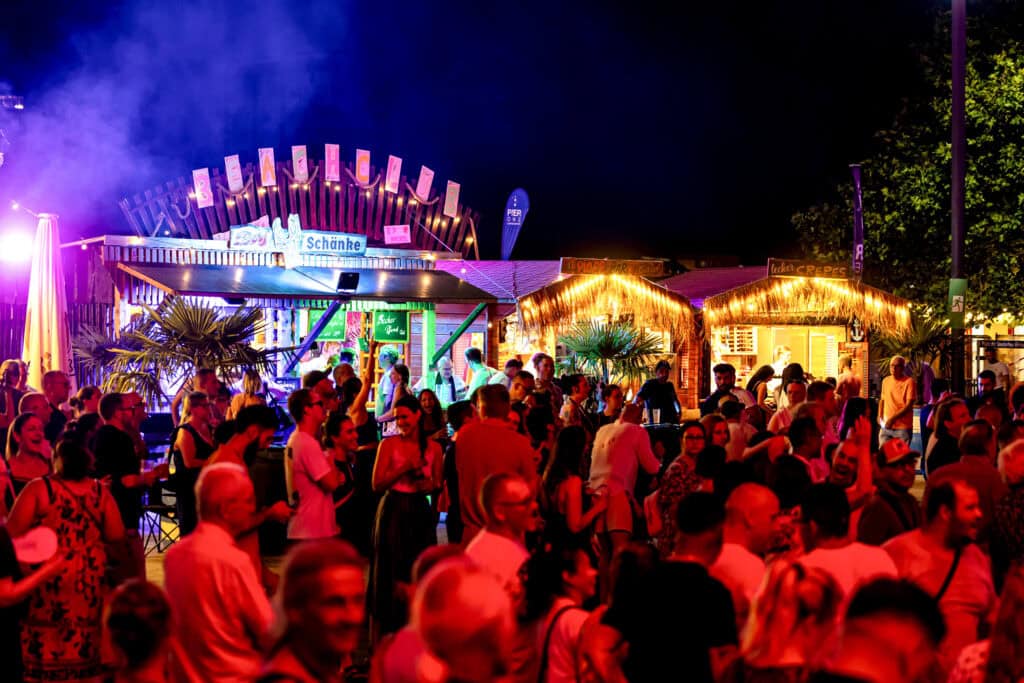 Menschen am Abend feiernd auf dem Rheinuferfest 2026